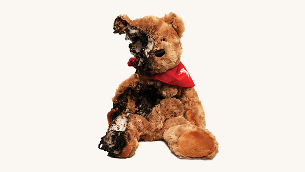 Image of a teddy bear that has been burnt by fire