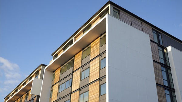 An apartment block exterior with wooden exterior and white cladding 